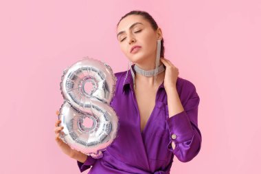 Pembe arka planda balon şeklinde 8 figürlü şık genç bir kadın. Uluslararası Kadınlar Günü