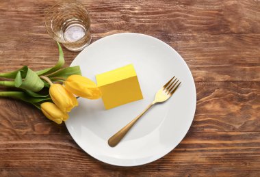 Boş kartlı masa ayarları ve ahşap zemin üzerinde laleler