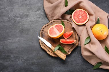 Koyu arkaplanda lezzetli kesilmiş greyfurt olan tahta