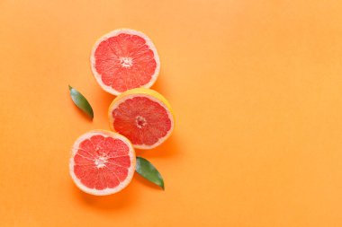 Turuncu arka planda taze greyfurt parçaları