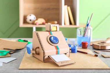 Masanın üzerinde el yapımı karton fotoğraf makinesi.