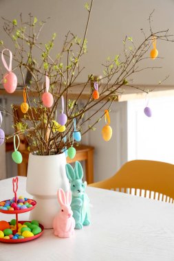 Mutfaktaki yemek masasında Paskalya yumurtası ve dekorun yanında dur.