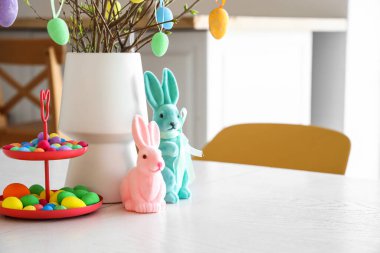 Paskalya yumurtaları ve tavşanlarla yemek masasında dur.