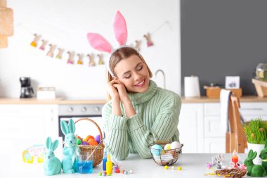 Evde tavşan kulaklı ve paskalya yumurtalı güzel bir kadın var.
