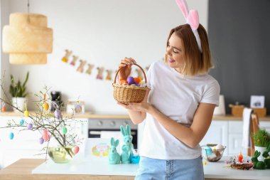 Evde tavşan kulaklı ve Paskalya sepetli güzel bir kadın var.
