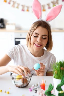Evde tavşan kulaklı ve paskalya yumurtalı güzel bir kadın var.