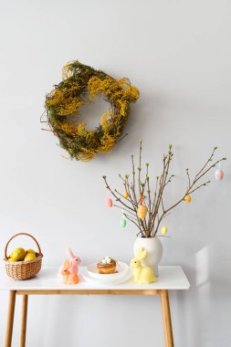 Limonlu sepet, çörek ve Paskalya dekoru ışık duvarının yanındaki masada.