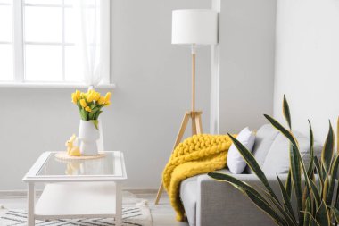 Laleli vazo, Paskalya tavşanı ve modern oturma odasındaki masada mum.