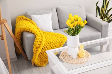 Laleli vazo, Paskalya tavşanı ve modern oturma odasındaki masada mum.