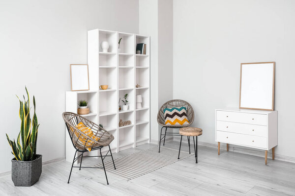 Interior of light room with big shelving unit and wicker armchairs