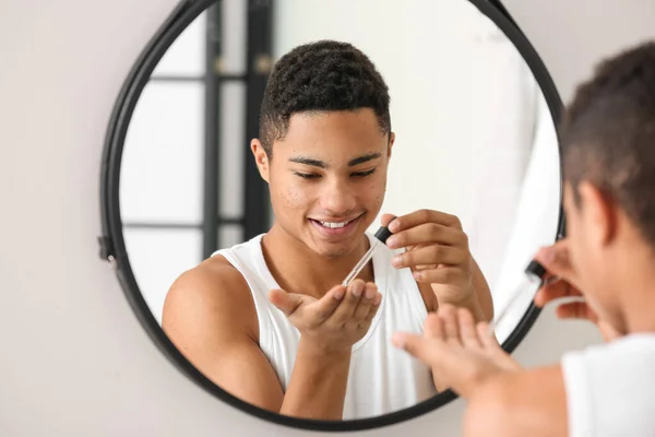 Young African American Guy Using Serum Skin Care Bathroom — Stock Photo, Image