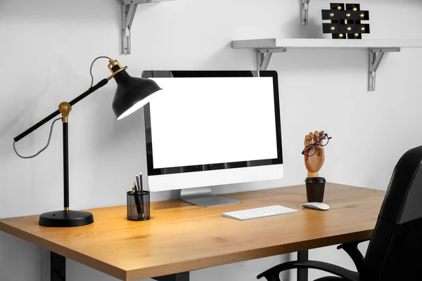 Arbetsplats Med Dator Pappershållare Pappersmugg Och Glödande Lampa Nära Ljusvägg — Stockfoto