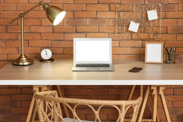 Modern Laptop Och Glödande Lampa Träbord Nära Tegelvägg — Stockfoto