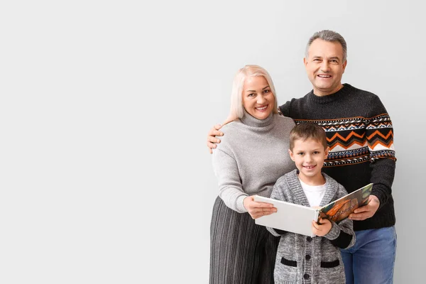 小男孩和他的祖父母穿着暖和的毛衣 阅读浅色背景的书 — 图库照片