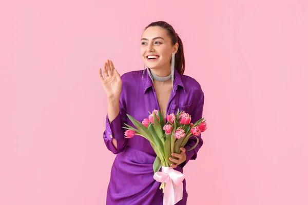 一个有着粉红色背景的郁金香束的时髦年轻女子 国际妇女日 — 图库照片