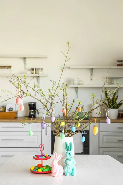 Mutfaktaki yemek masasında Paskalya yumurtası ve dekorun yanında dur.
