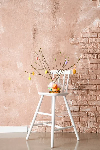 Vase Mit Ästen Und Ostereiern Auf Stuhl Neben Farbwand — Stockfoto