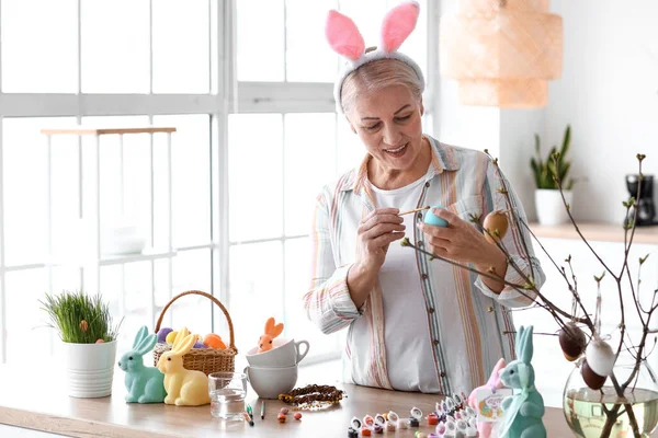 Rijpere Vrouw Schilderen Paaseieren Thuis — Stockfoto