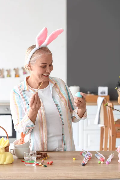 Rijpere Vrouw Schilderen Paaseieren Thuis — Stockfoto