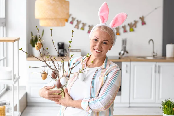 Evde tavşan kulaklı ve paskalya desenli olgun bir kadın.