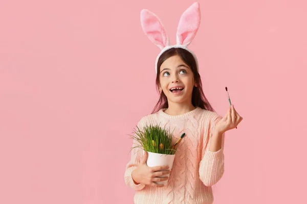 かわいいウサギの耳 観葉植物とピンクの背景にブラシを持つ女の子 イースターのお祝い — ストック写真