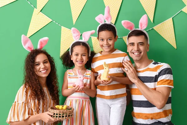 緑の背景にイースターエッグとウサギの幸せな家族 — ストック写真