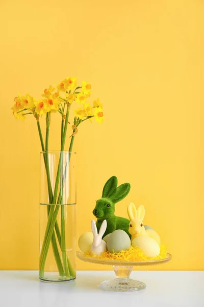 Álljon Húsvéti Tojások Nyulak Gyönyörű Virágok Vázában Asztalon Közel Színes — Stock Fotó