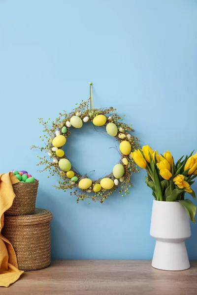 Húsvéti Koszorú Kosár Tojással Tulipánnal Asztalon Színes Fal Mellett — Stock Fotó