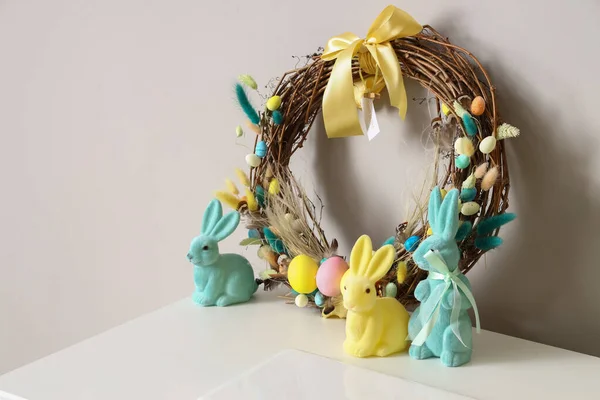 Gyönyörű Húsvéti Koszorú Nyulak Asztalon Fényfal Közelében — Stock Fotó