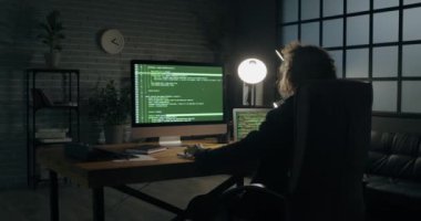 Karanlık odada bilgisayar kullanan programcı
