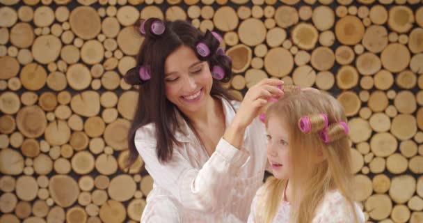 女性と彼女の小さな娘使用毛カーラーでホーム — ストック動画