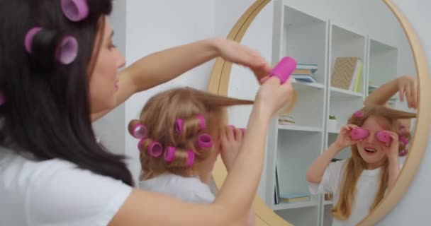 Vrouw Krullen Haar Van Haar Dochtertje Voorkant Van Spiegel — Stockvideo