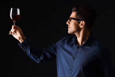 Genç erkek şarap tadıyor arka planda.