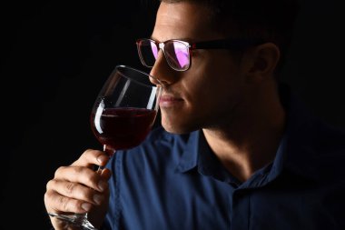 Genç erkek şarap tadıyor arka planda.