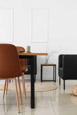 Masalı ve siyah koltuklu hafif yemek odasının içi.