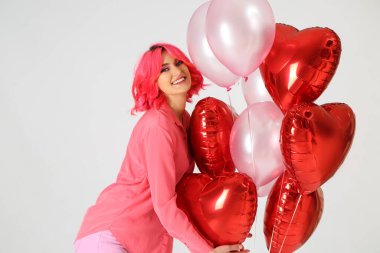Açık arkaplanda parlak saçlı ve hava balonları olan şık bir kadın. Sevgililer Günü kutlaması