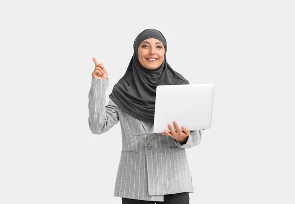 Muslimische Sekretärin Mit Laptop Zeigt Auf Etwas Auf Hellem Hintergrund — Stockfoto