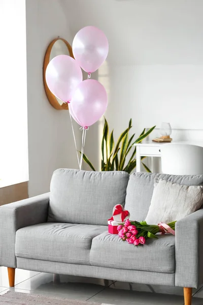 房间里的沙发上有一束郁金香花和礼物 — 图库照片