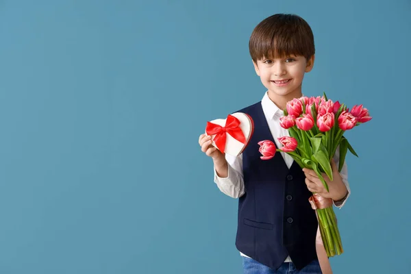 Kleiner Junge Mit Geschenk Und Blumenstrauß Auf Farbigem Hintergrund — Stockfoto
