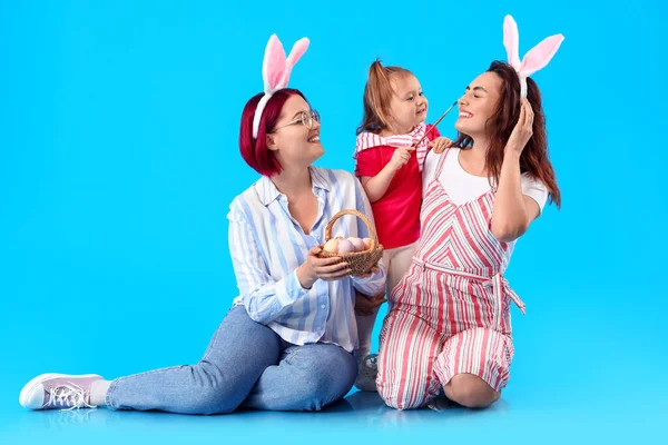 Šťastný Lesbický Pár Malou Dcerou Velikonoční Vajíčka Štětec Barevném Pozadí — Stock fotografie