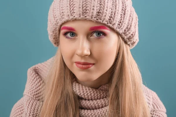 色の背景にニット帽で創造的な眉を持つ女性の肖像画 — ストック写真