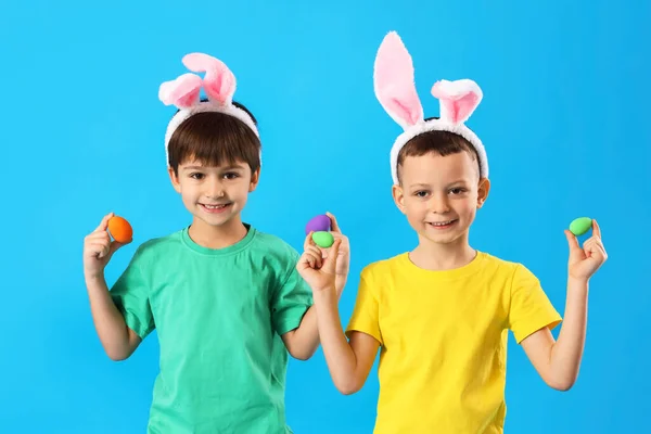 Niedliche Kleine Jungen Mit Hasenohren Und Ostereiern Auf Blauem Hintergrund — Stockfoto