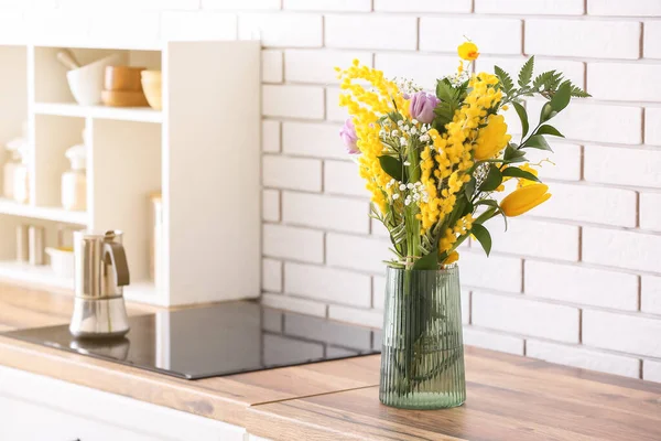 白いレンガの壁の近くのキッチンカウンターで美しい花と花瓶 — ストック写真