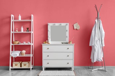 İçinde bornozlar, çekmeceler ve raflar olan şık bir oda.