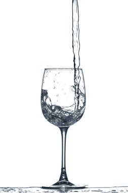 Beyaz arka planda su sıçramış bir bardak temiz su.