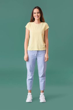 Yeşil arka planda şık tişörtlü güzel bir bayan.