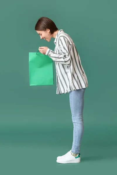 緑の背景にショッピングバッグと若い女性 — ストック写真