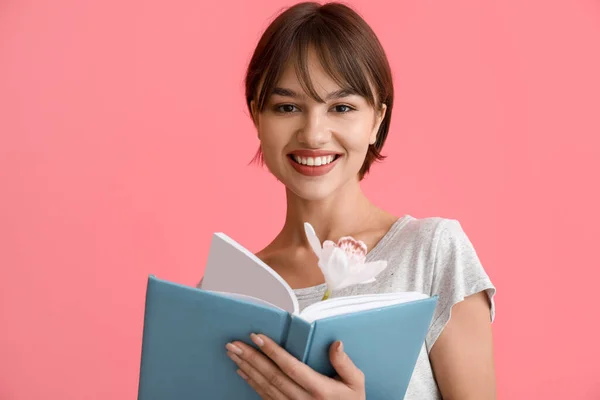 Красивая Молодая Женщина Книгой Цветами Розовом Фоне — стоковое фото