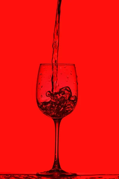 Ποτήρι Καθαρού Νερού Βουτιά Κόκκινο Φόντο — Φωτογραφία Αρχείου
