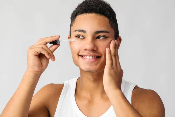 Young African American Guy Serum Skin Care Grey Background — Stock Photo, Image